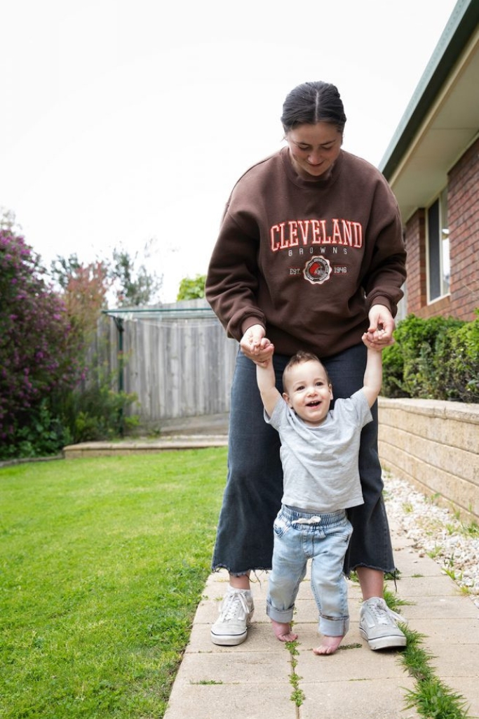 Mother giving testimonials while holding child while walking
